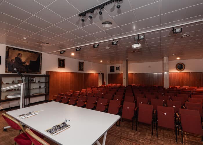Salle Concert avec estrade, table, chaises, et sièges